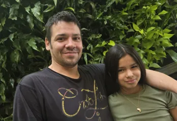 Robert and Sapphira pose in front of plant wall at the Downtown Y