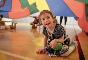 children playing with a parachute in the gym