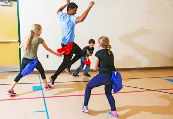 kids playing flag football with camp counsellor