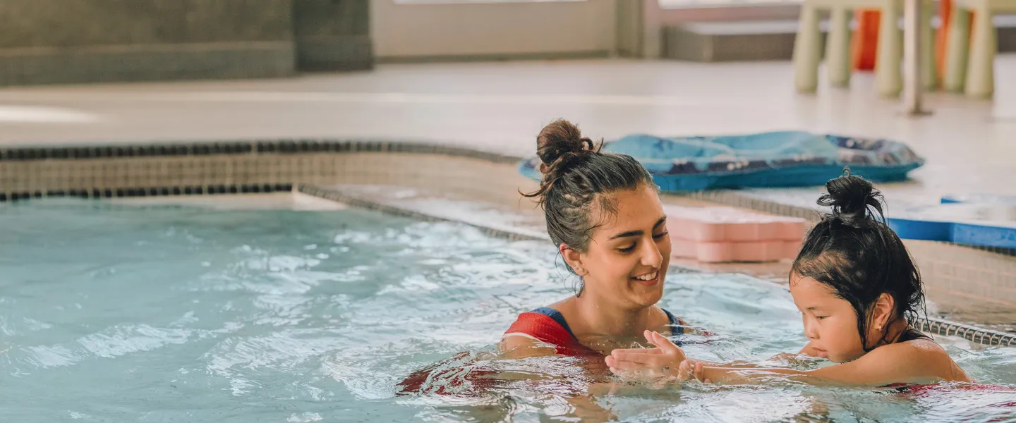Y staff teaching child to swim