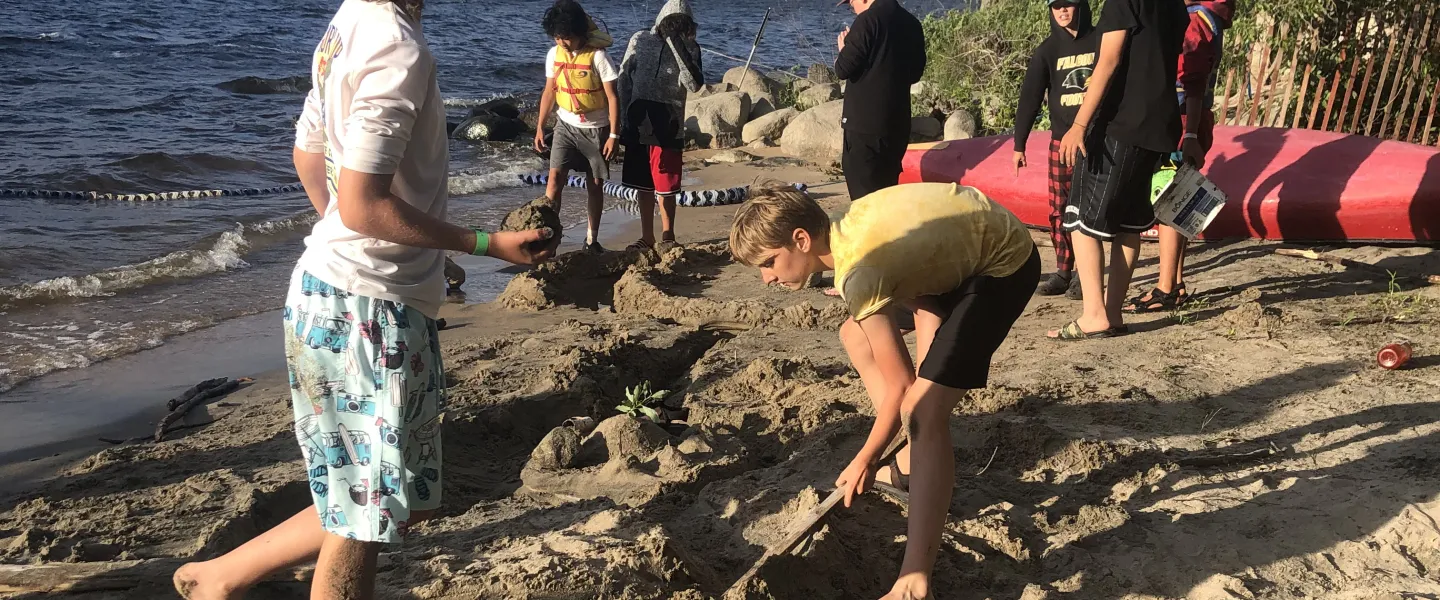 campers play in the sand on the island