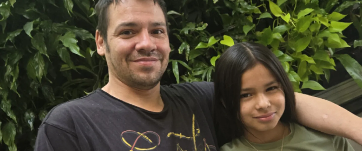 Robert and Sapphira pose in front of plant wall at the Downtown Y