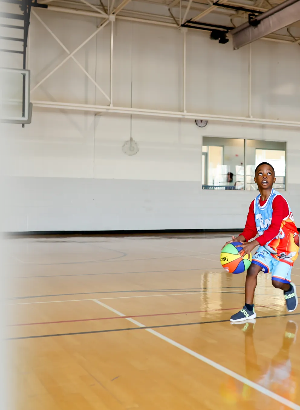 2 young boys playing basketball in the gymnasium