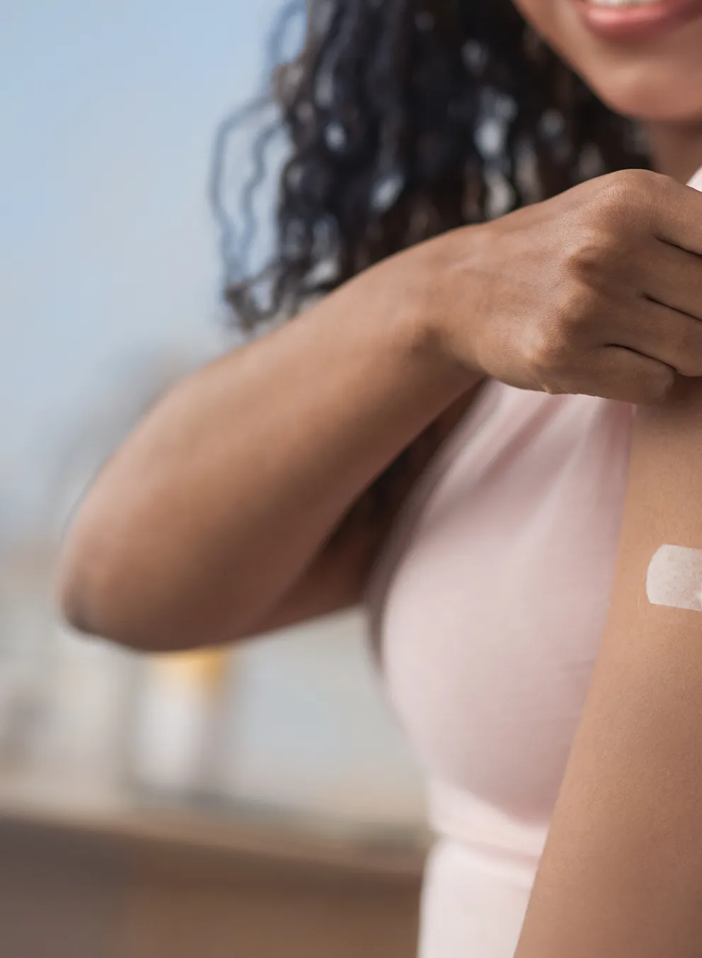 Image of a woman pulling up her sleeve to show bandage