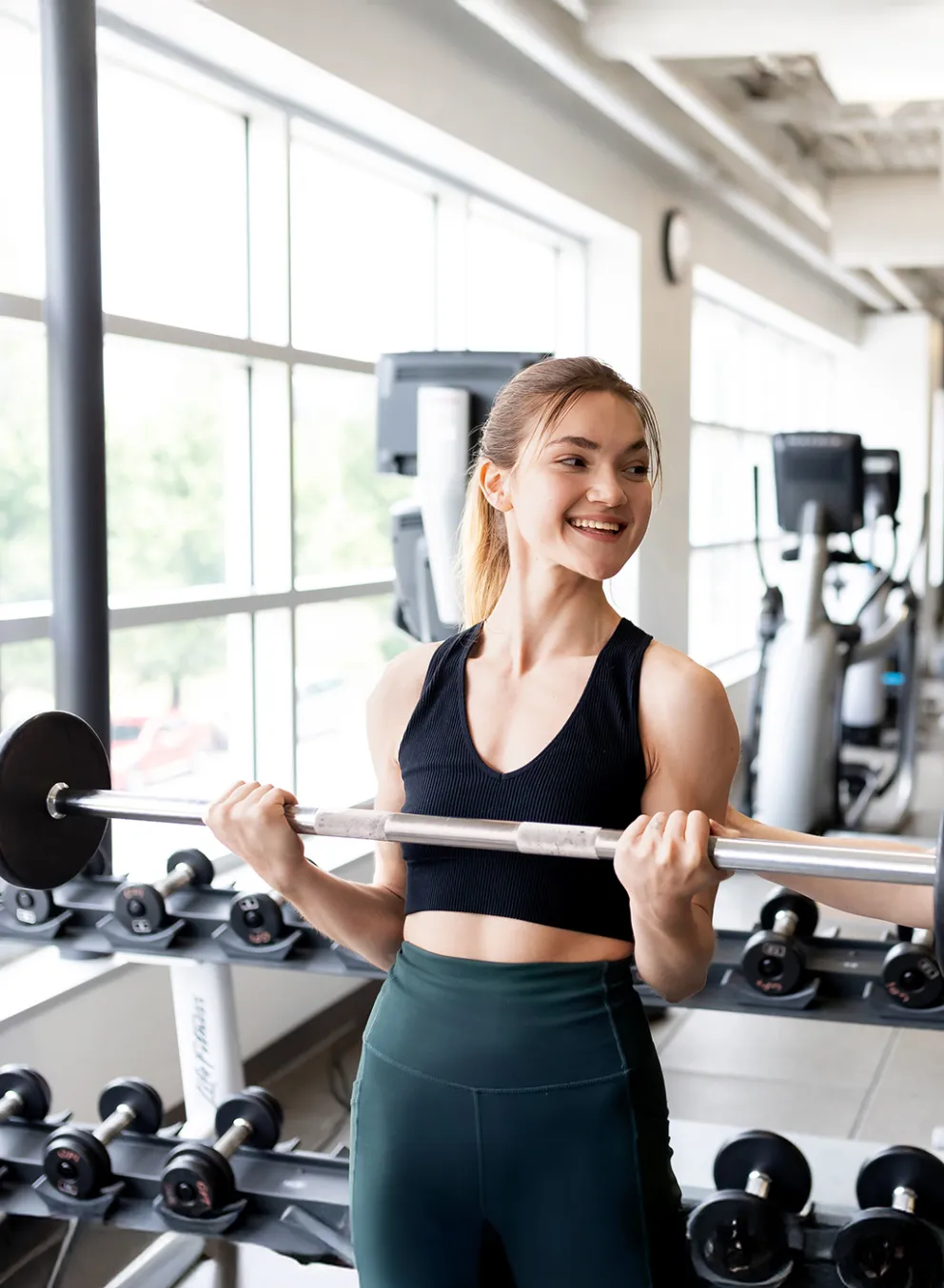 Y Fitness staff talking to young woman in gym