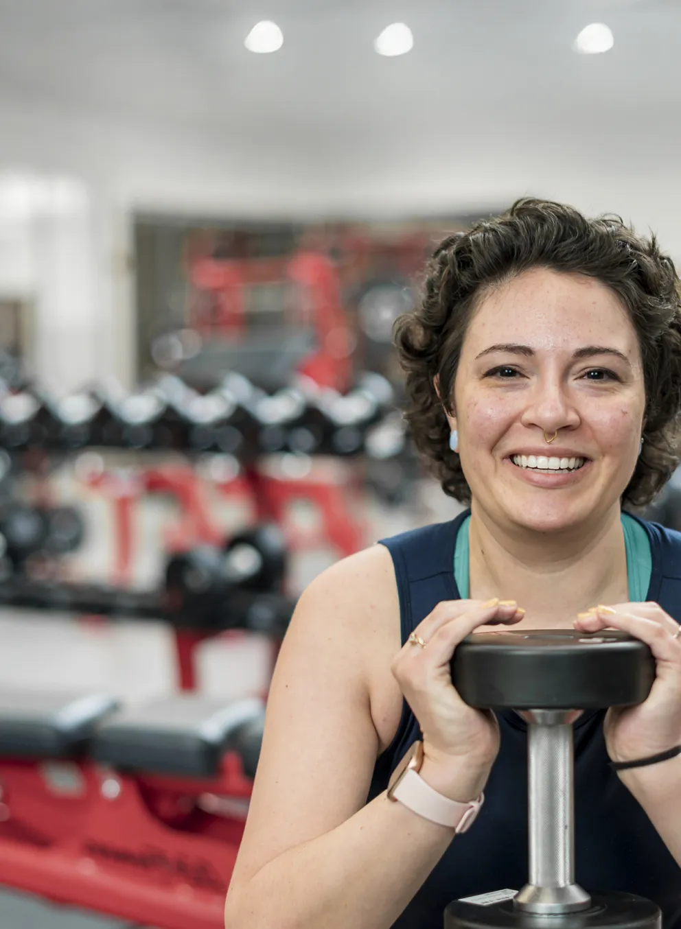 female holding handweights at a gym