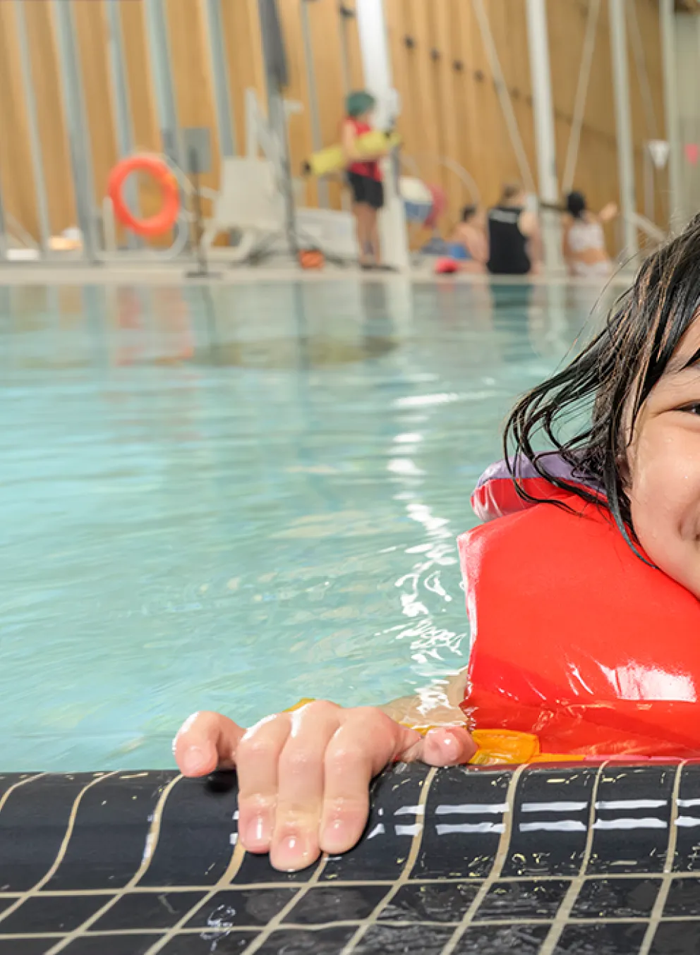 smiling child in pool at water's edge
