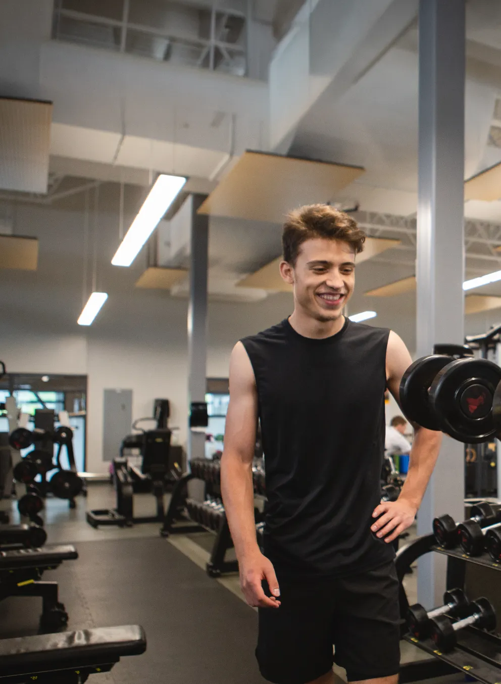 young male adults using dumbbells in a gym