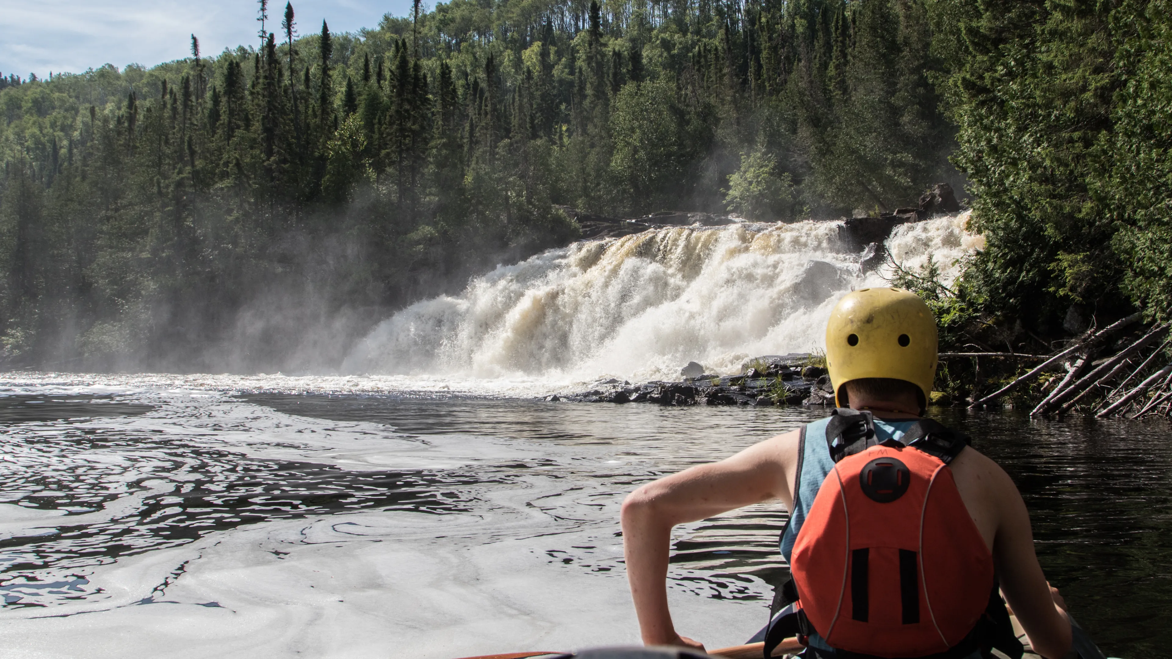 canoeist looking at waterfall scenery