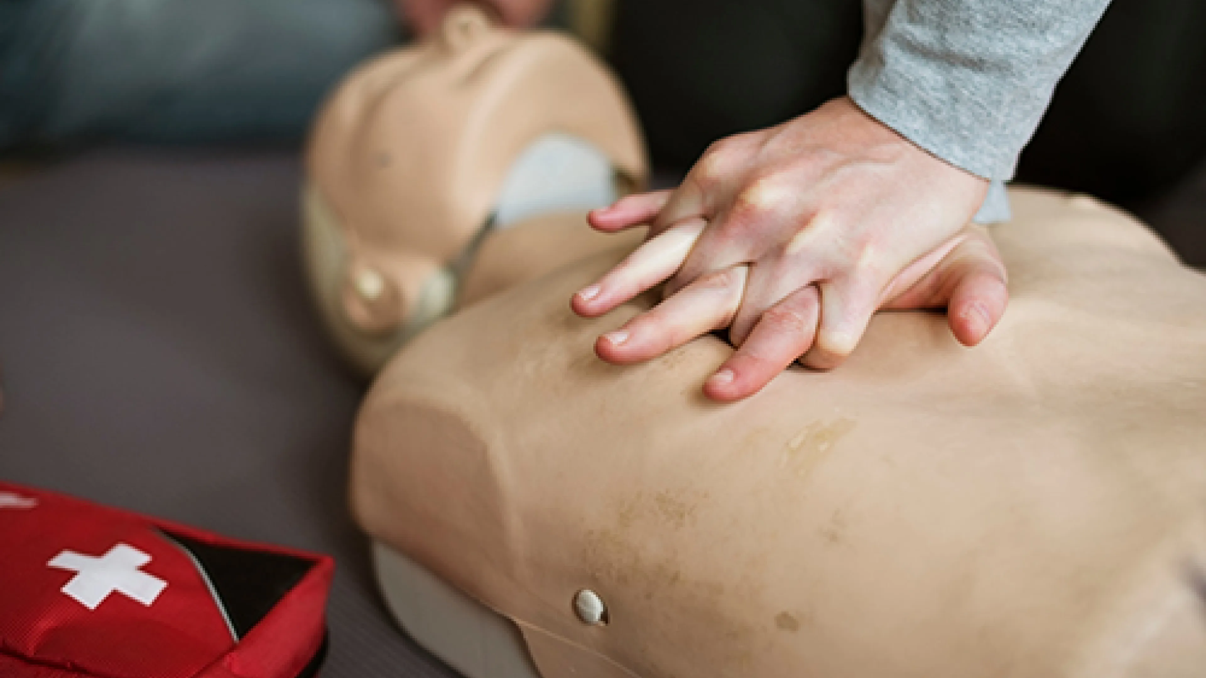 [Image] close-up of person performing chest compressions on CPR dummy