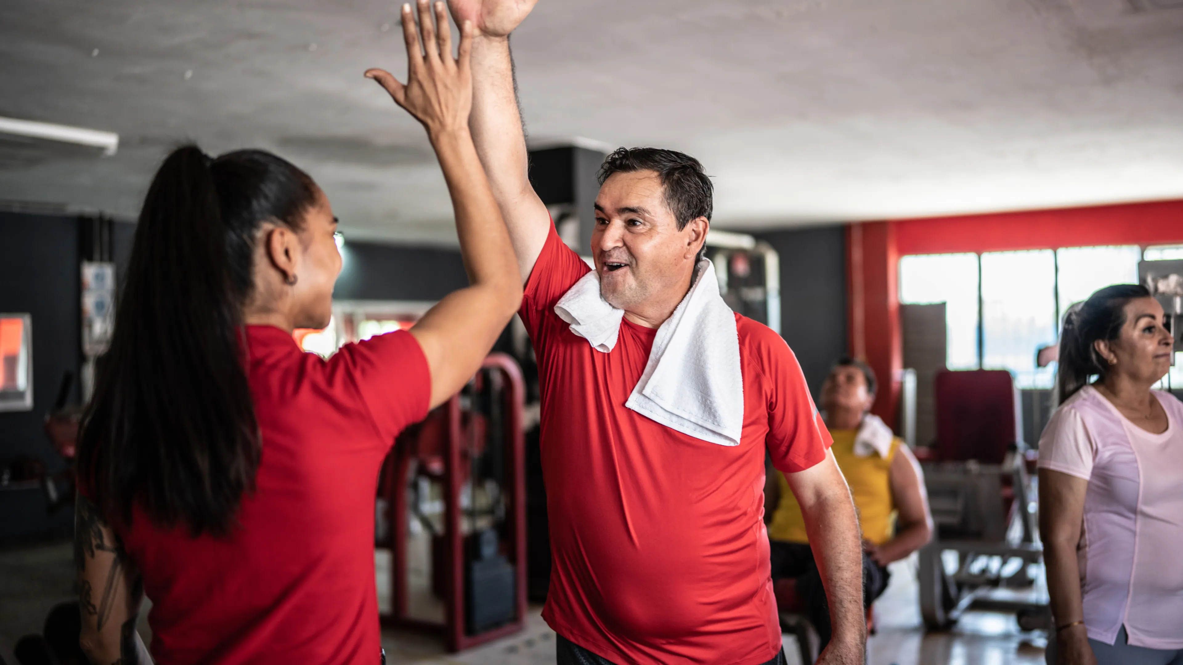 [Image] Man in fitness centre giving coach a high five