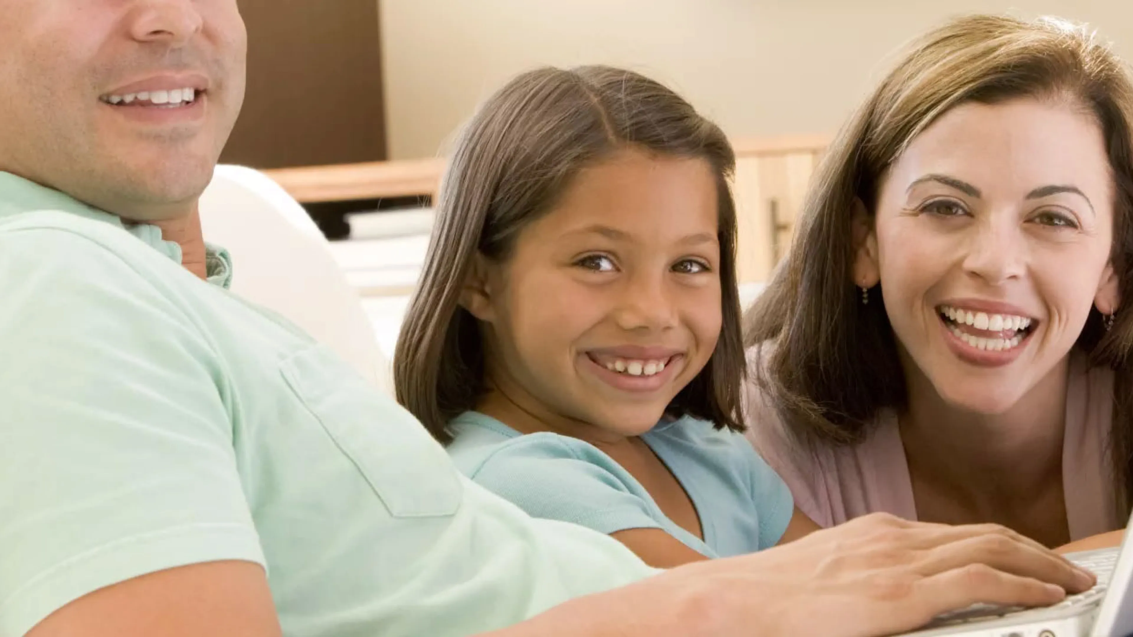 image of family sitting on the couch with a laptop