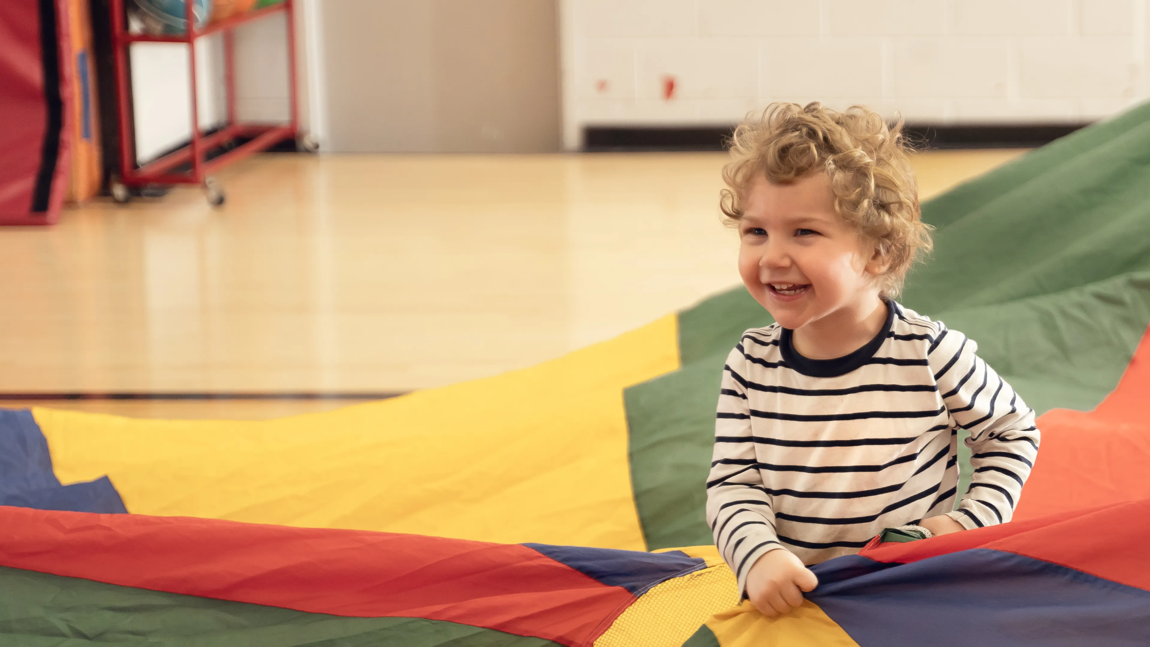 Preschool kid playing with parachute