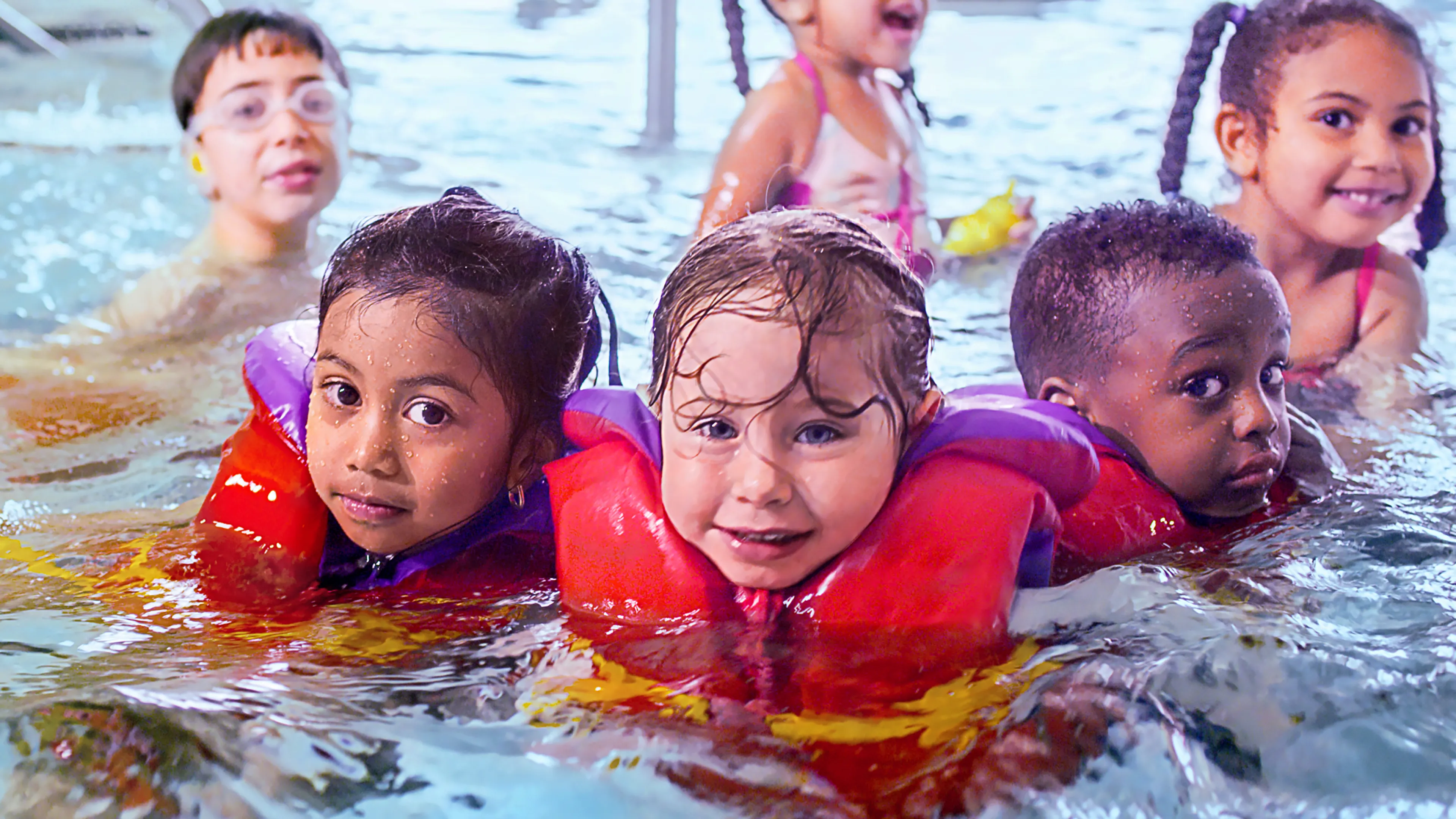 Group of children wearing lifejackets in the pool