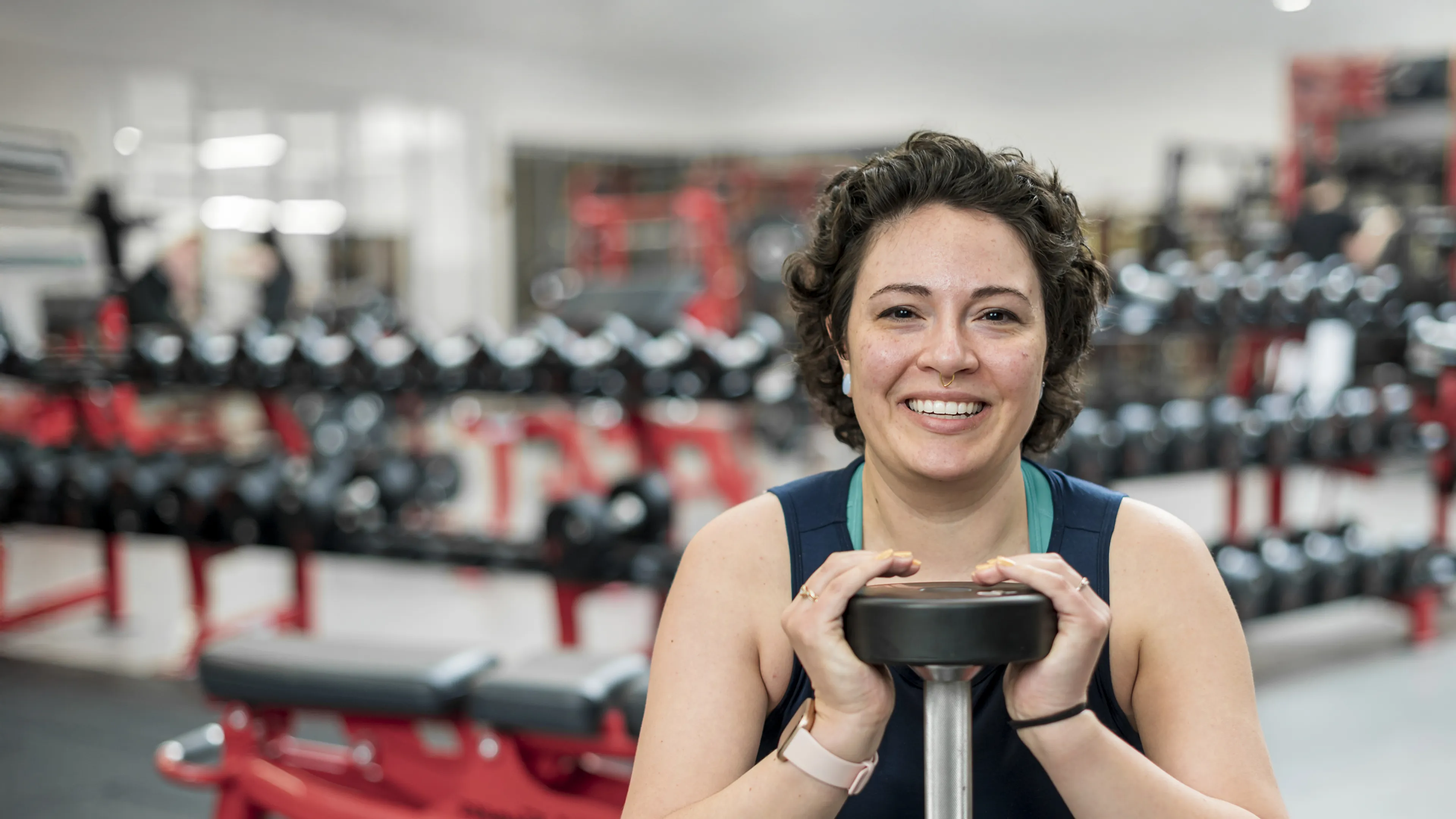 female holding handweights at a gym