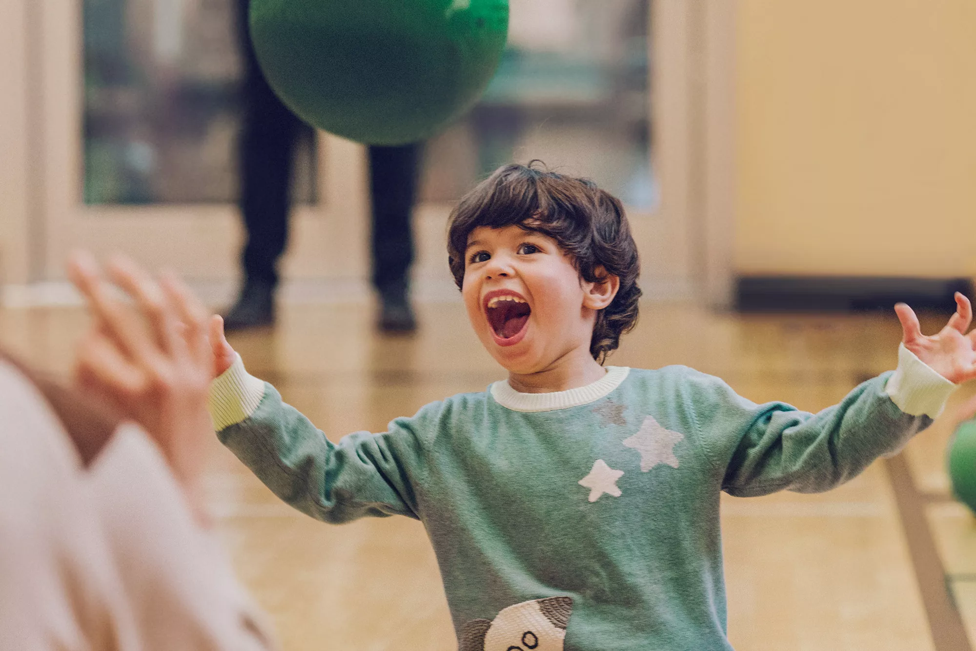 Young Boy Playing with a Green Ball