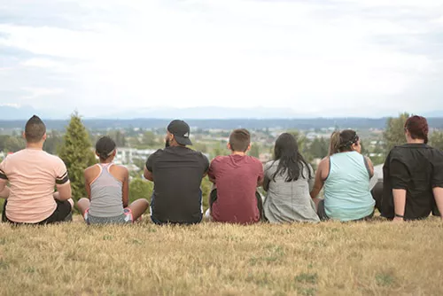 Photo of Youth Sitting Taken from Behind