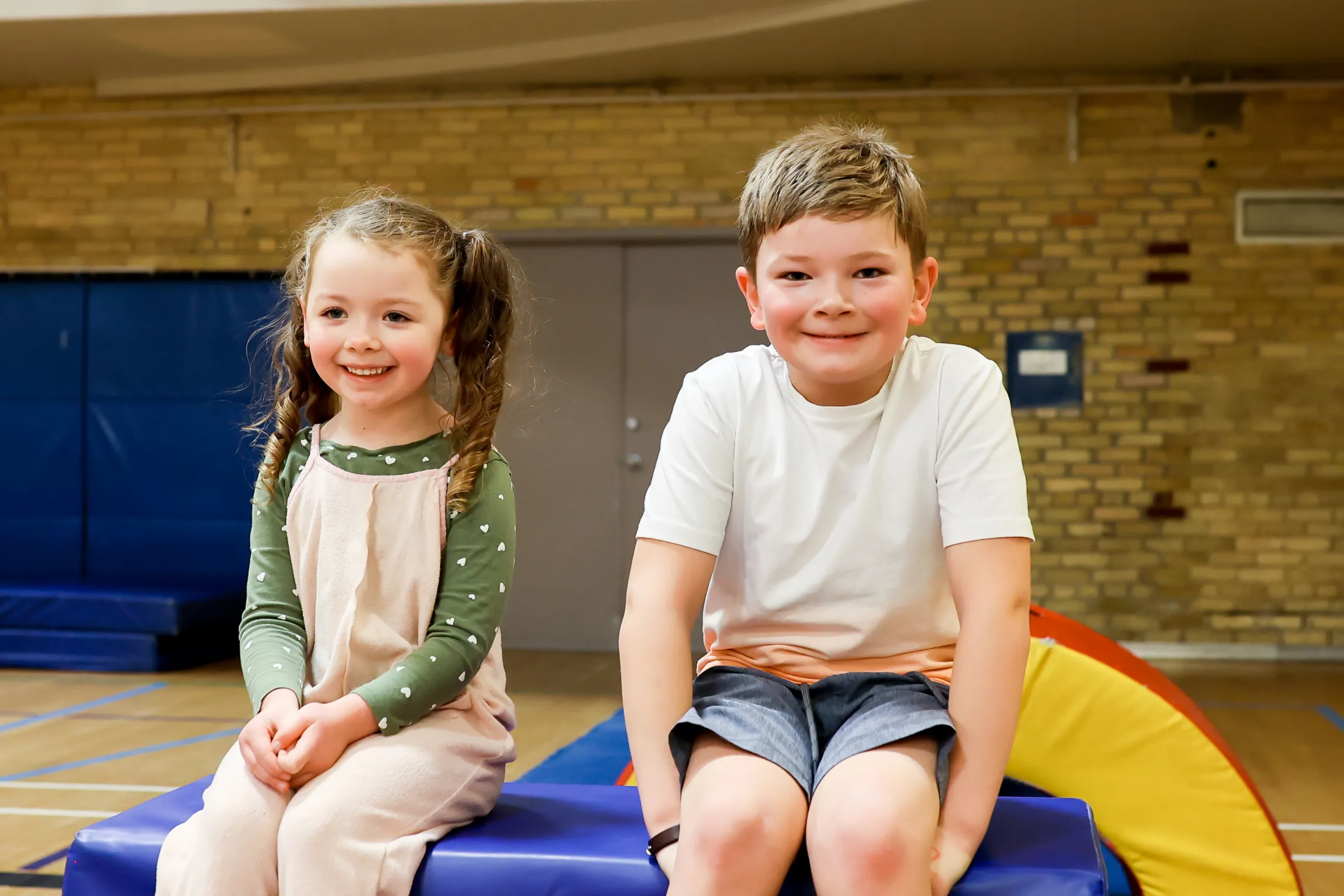 Two Kids at Obstacle Course Sitting on Large Foam Box