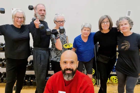 Y instructor, Javi, posing with Judy and class