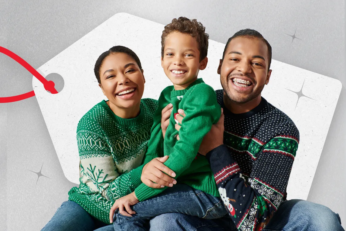 [image] family of three smiling, wearing festive sweaters