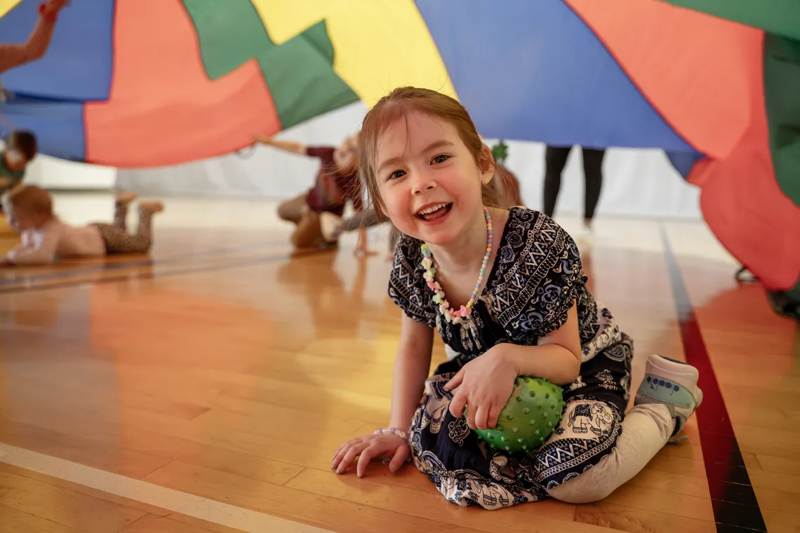 children playing with a parachute in the gym