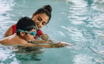 Swimming instructor teaching a young swimmer in the pool