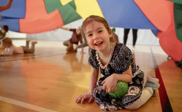 children playing with a parachute in the gym