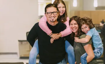 family of 4 smiling at camera