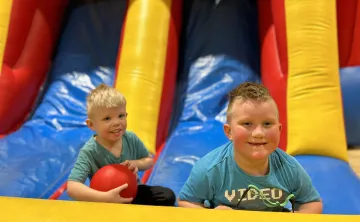 2 boys playing at bottom of a bouncy castle