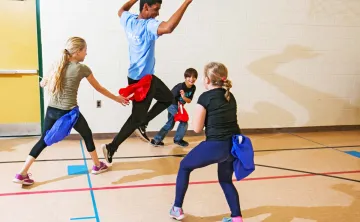 kids playing flag football with camp counsellor